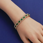 Smaragdgroene stenen schakelarmband in goudkleur