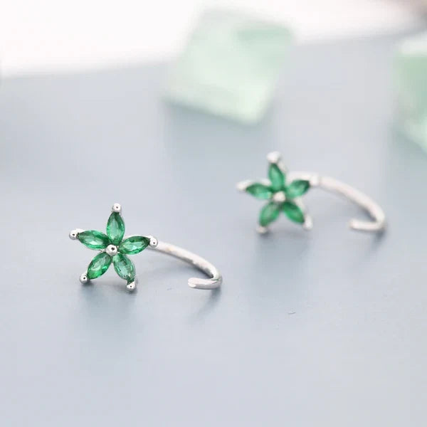Bloem-huggie-oorringen met groene stenen