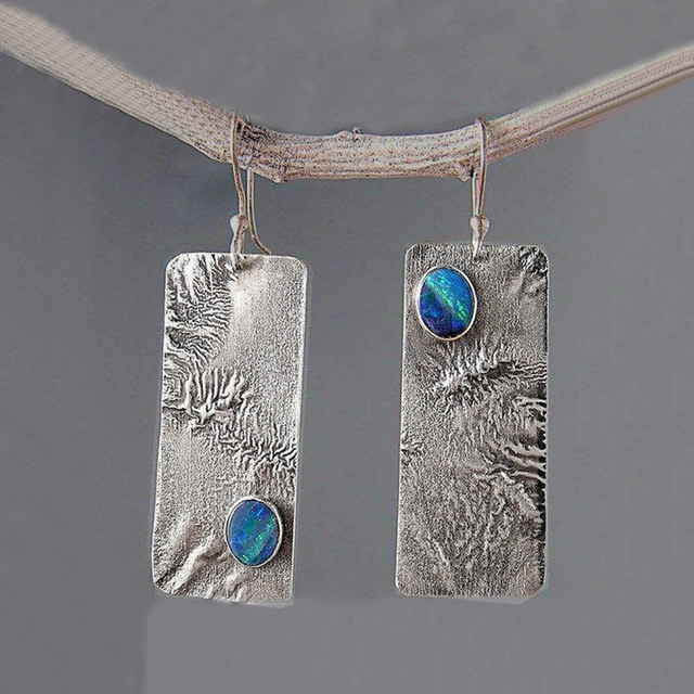 Zilverkleurige staafoorbellen met textuur en blauwe steen in vintagestijl