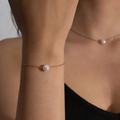 Fijne goudkleurige schakelarmband met enkele parel