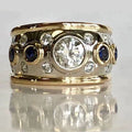 Bred tofarvet ring med rund zirkonia og mørke detaljer