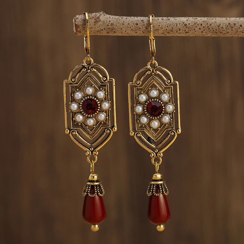 Vintage goudkleurige oorbellen met rood kristal en parel