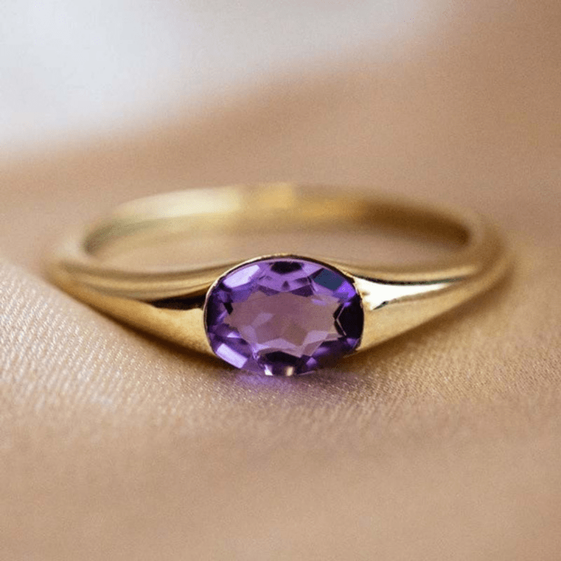 Ovale ring met paars kristal aan smalle goudkleurige band