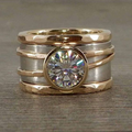 Bred tofarvet ring med rundt glas i midten