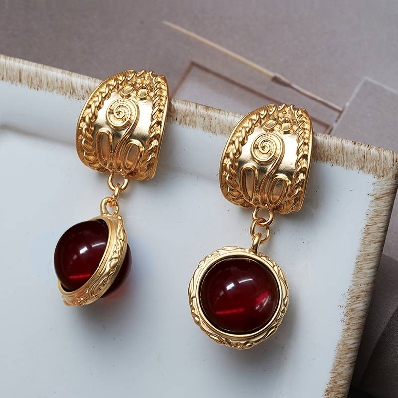 Vintage goudkleurige oorbellen ingelegd met rode steen