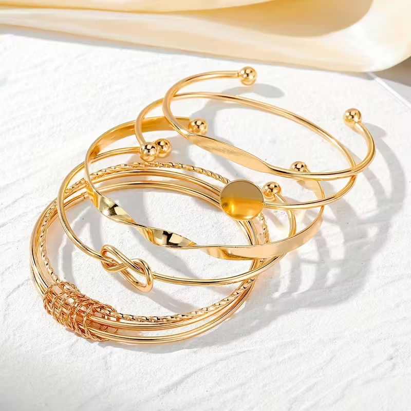 Goudkleurige bangleset met knoop en schijfje