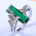 Lange ring met groen kristal en zilverkleurige bladvleugels