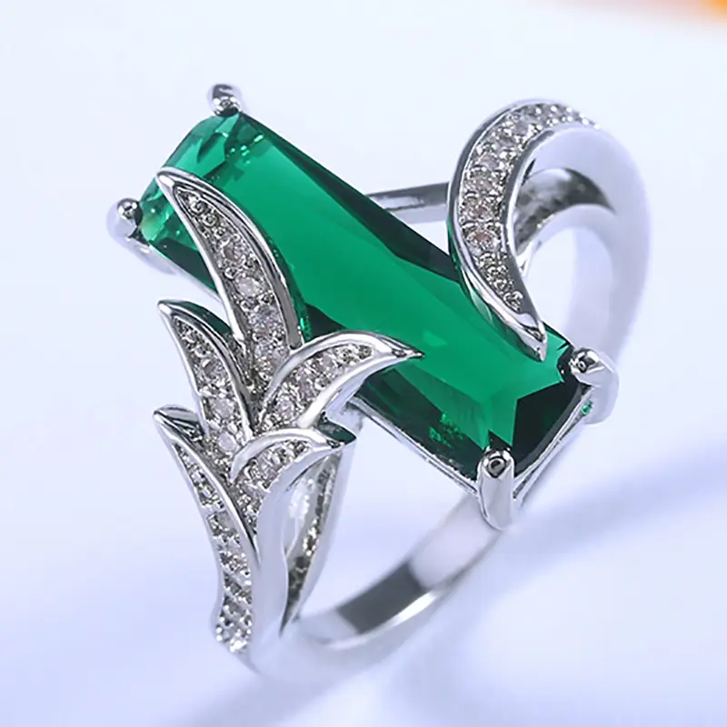 Lange ring met groen kristal en zilverkleurige bladvleugels