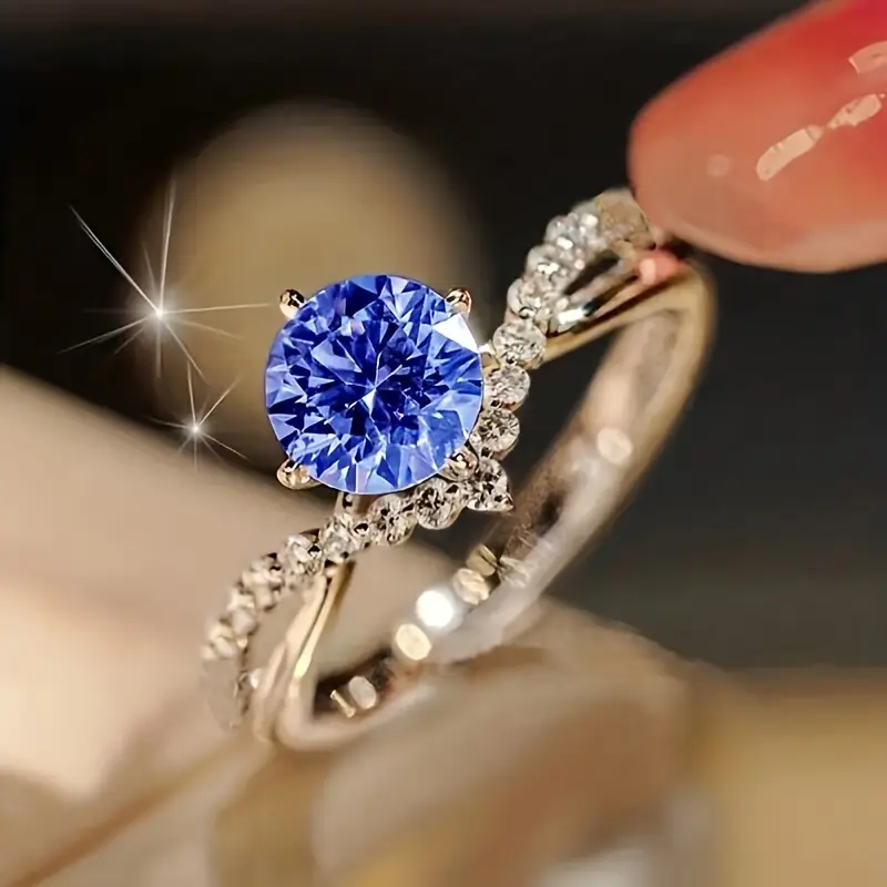Solitairring met blauw kristal en band met bladaccent