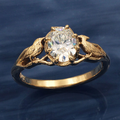 Guldfarvet ring med hvid krystal og eksotisk design