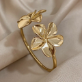 Goudkleurige open armband (cuff) met bloem