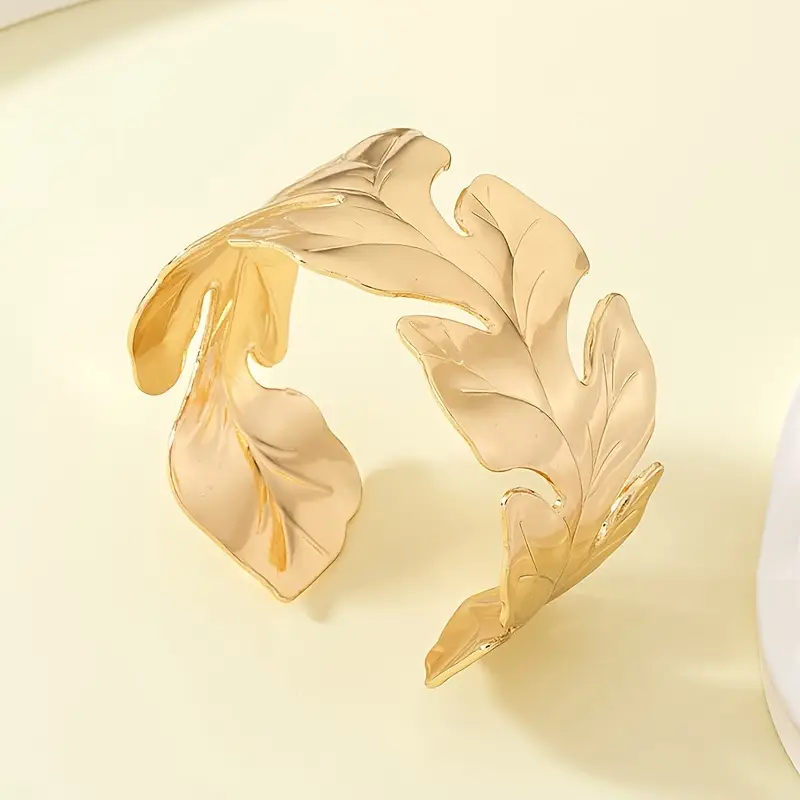 Brede goudkleurige open armband (cuff) met blad