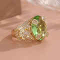 Ronde gelaagde goudkleurige ring met olijfgroen kristal