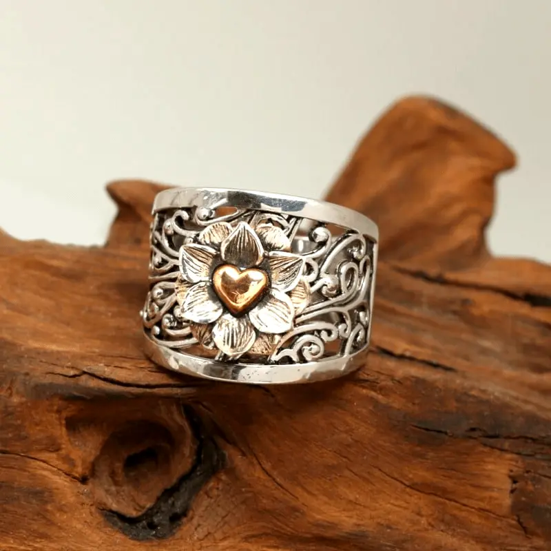 Zilverkleurige ring met bloem en goudkleurig hart