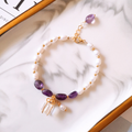 Goudkleurige armband met paarse stenen en parels