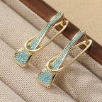 Goudkleurige paperclip-oorhangers met synthetisch turkoois