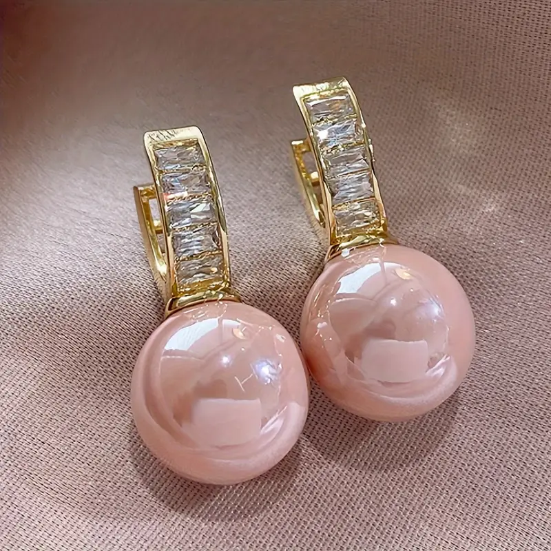 Goudkleurige oorbellen met roze parel en zirkonia