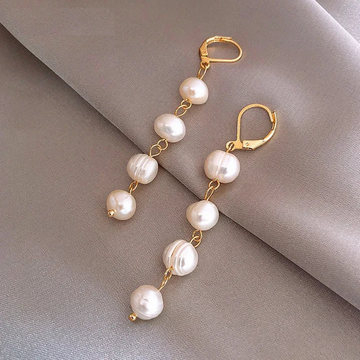 Lange goudkleurige kettingoorbellen met parels