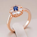 Ronde goudkleurige ring met blauw kristal