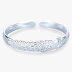 Open pauwarmband met uitwaaierend detail