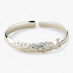 Open pauwarmband met uitwaaierend detail