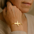 Goudkleurige bedelarmband met vliegtuigje